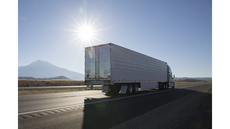 Semi-trailer truck motors along empty highway