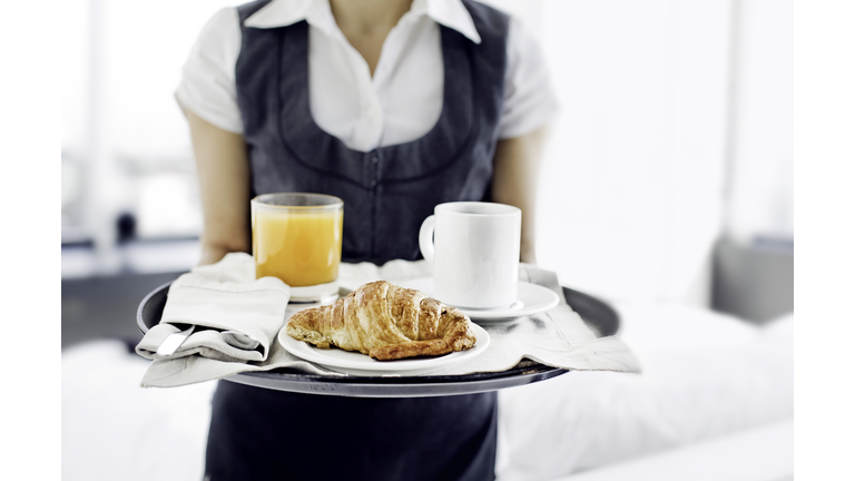 Room service hotel staff carries breakfast tray