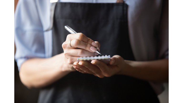 Waitress wear apron holding notepad pen write notes take order