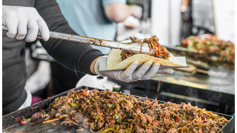 Chef at a street food market preparing a taco