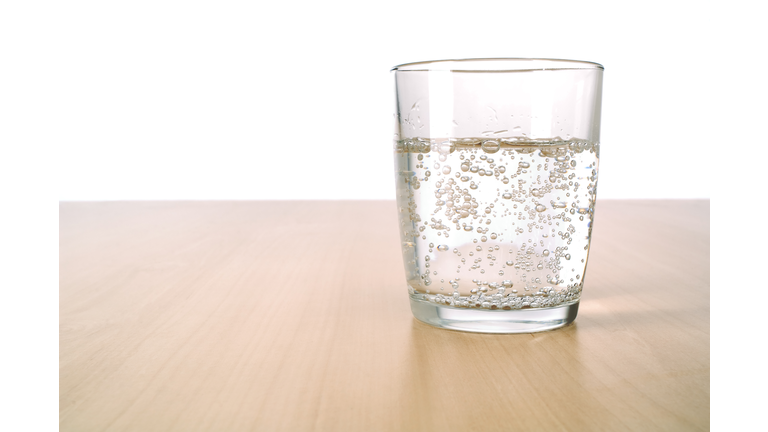 Glass of sparkling water on table