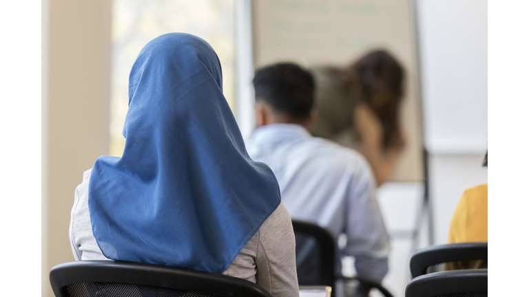 Rear view of woman wearing hijab sitting in classroom