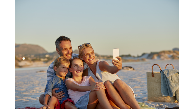 Family posing for selfie on beach
