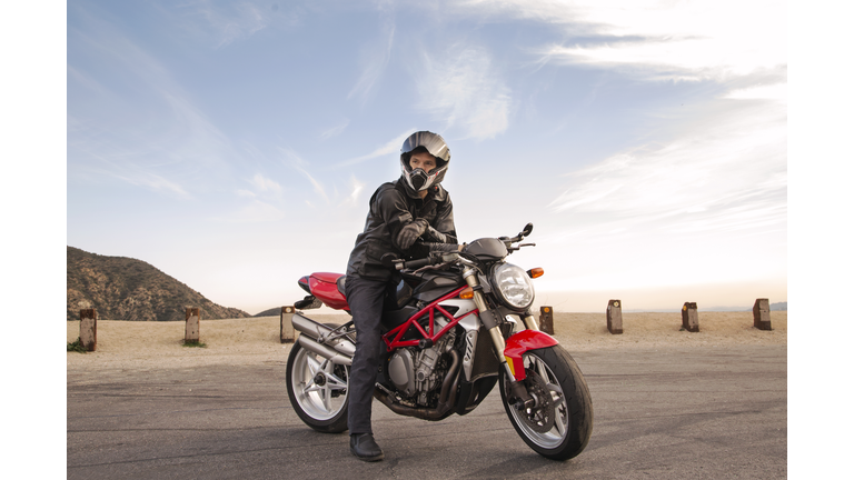 Portrait of Biker sitting on motorcycle wearing helmet