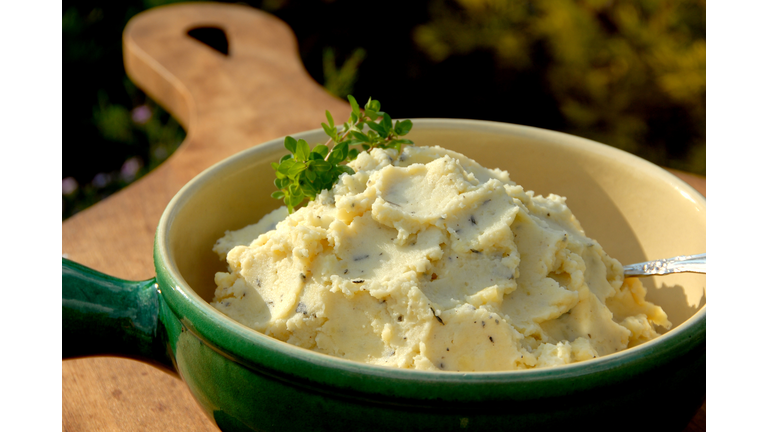 A green bowl of herbed mashed potatoes