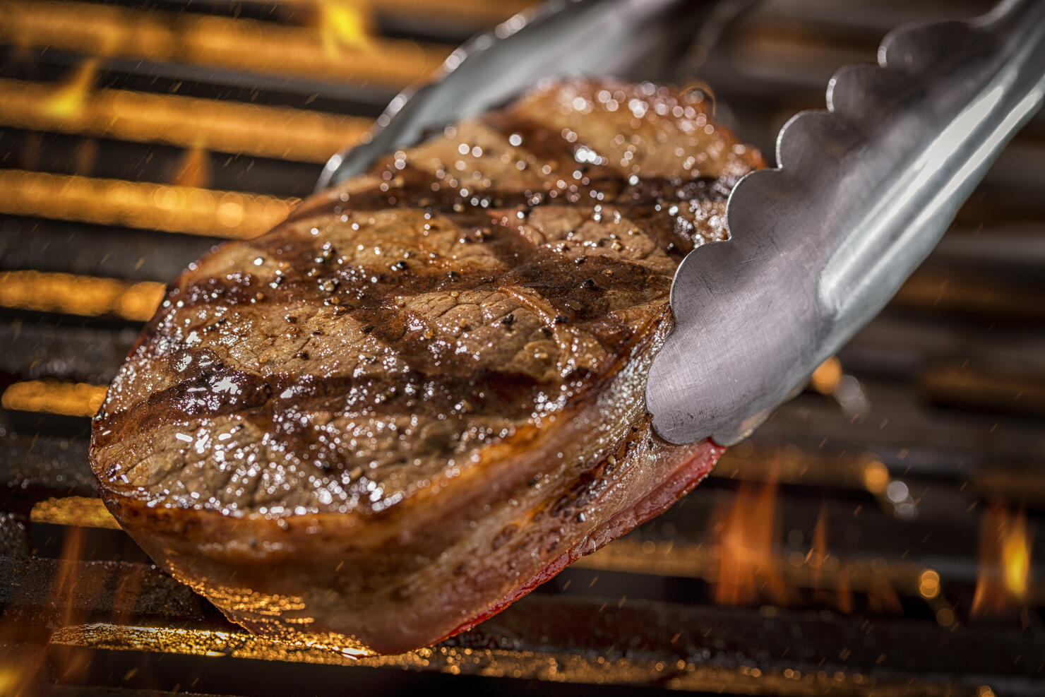 Grilling Filet Mignon Steak on a grill with Fire
