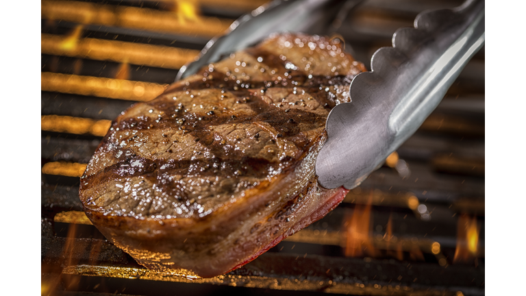 Grilling Filet Mignon Steak on a grill with Fire