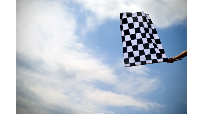 Checkered flag waving under a blue sky