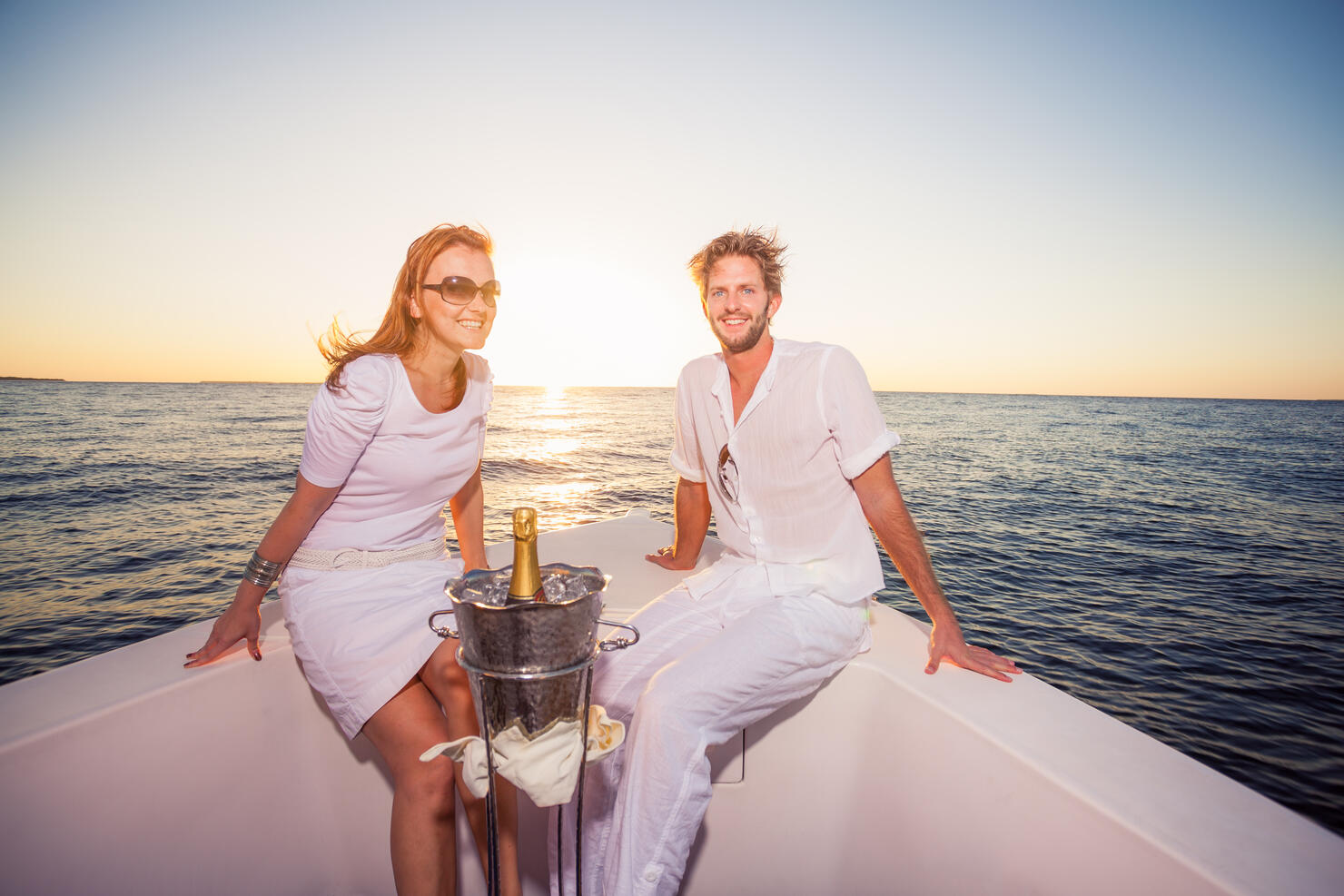 rich couple on sunset cruise with champagne