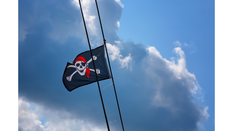 Jolly Roger - Flag of a Pirate skull and cross bones pirate flag waving in the wind