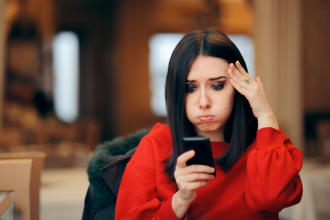 Stressed Woman Reading Text Message on Smartphone