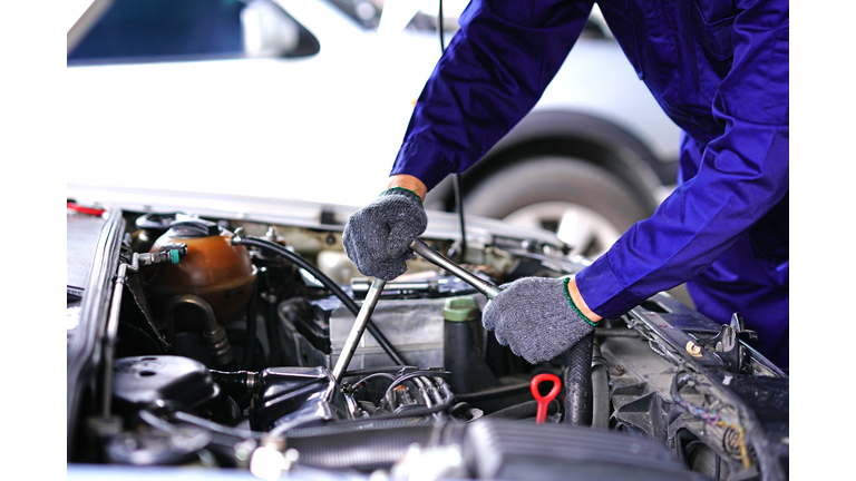 Auto mechanic using repair tools check car in Garage