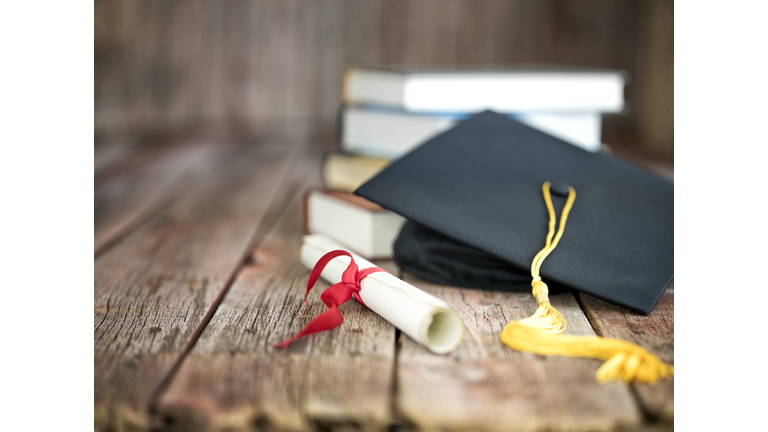 Graduation Cap and Diploma Concept on a Wood Background