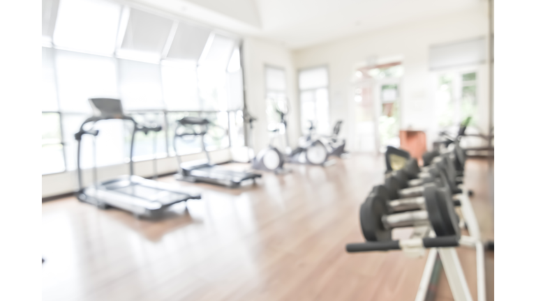 Blur gym background fitness center or health club with blurry sports exercise equipment for aerobic workout and bodybuilding