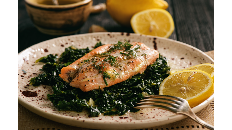 Baked salmon served on stewed spinach with lemon butter sauce.