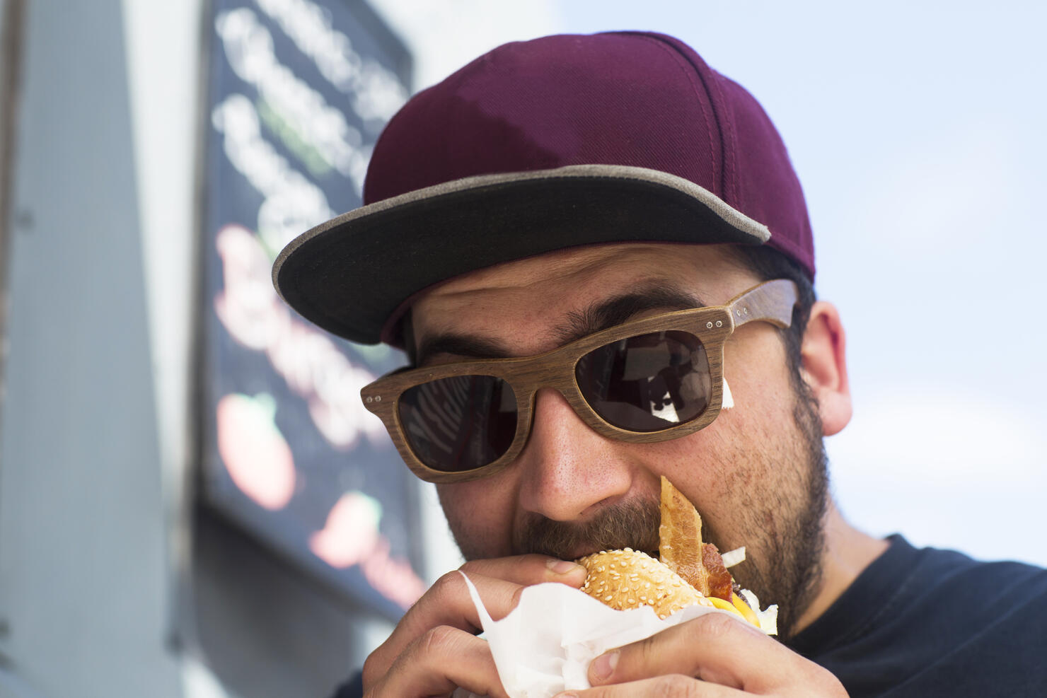 Male customer eating hamburger from fast food van