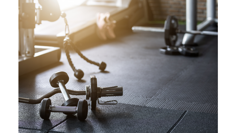 Gym background Fitness weight equipment on empty dark floor