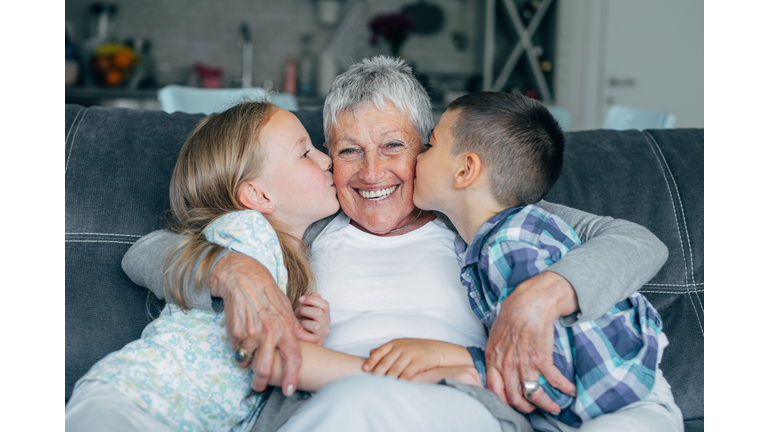 Lovely kids kissing their grandmother