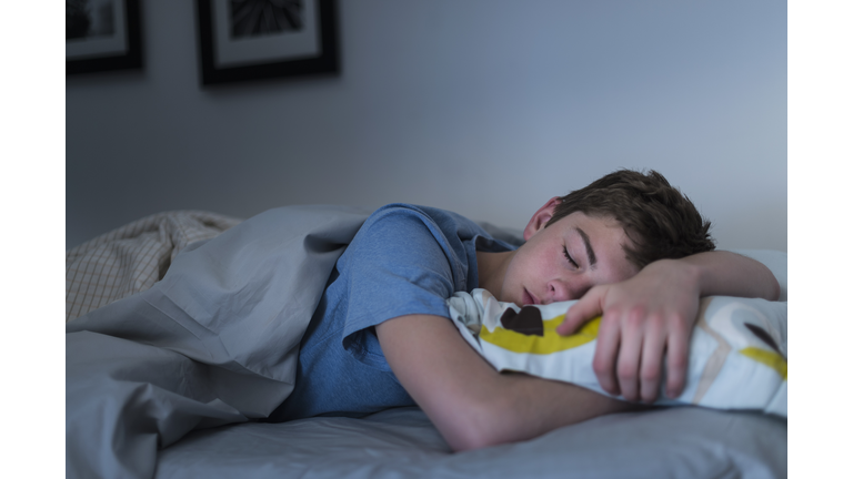 USA, New Jersey, Jersey City, Teenage boy (16-17) sleeping in bed