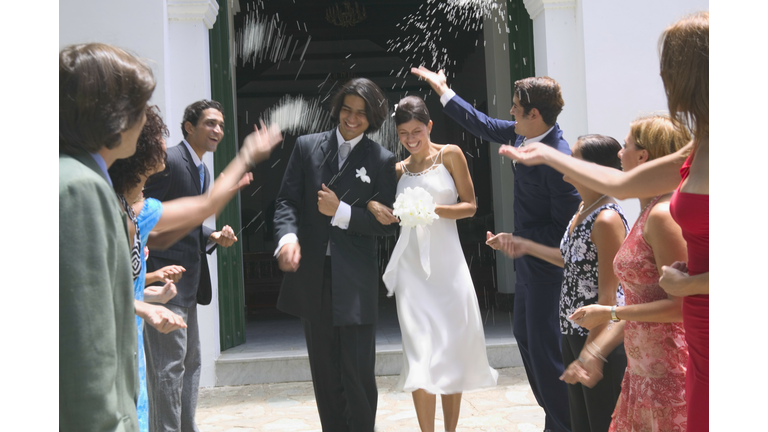 Wedding guests tossing rice at newlyweds (blurred motion)