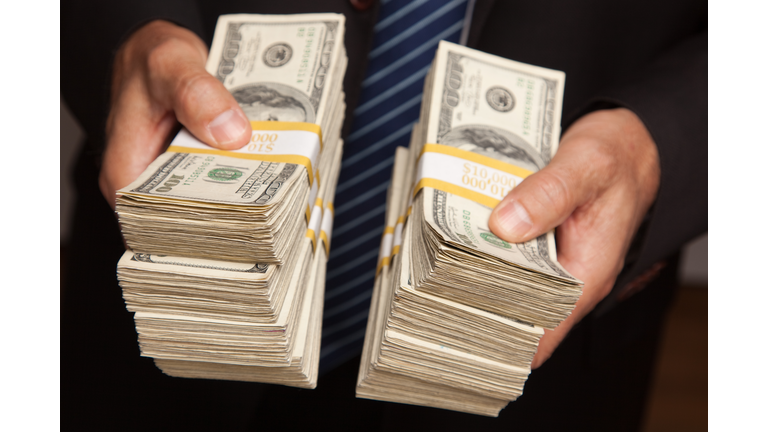 Businessman Handing Over Stacks of Money