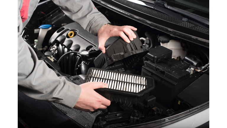 Mechanic changing the air filter on a car