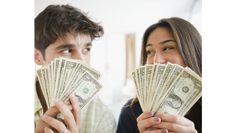Couple holding handfuls of money