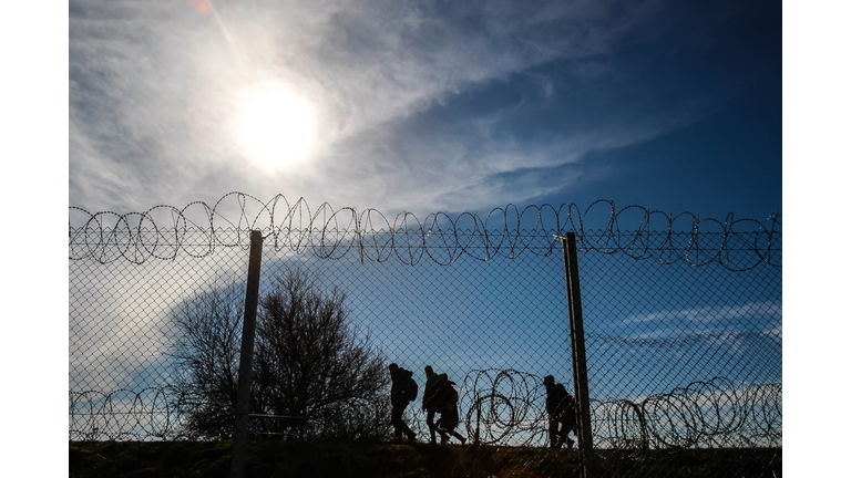 Refugees Running On Border Against Sky