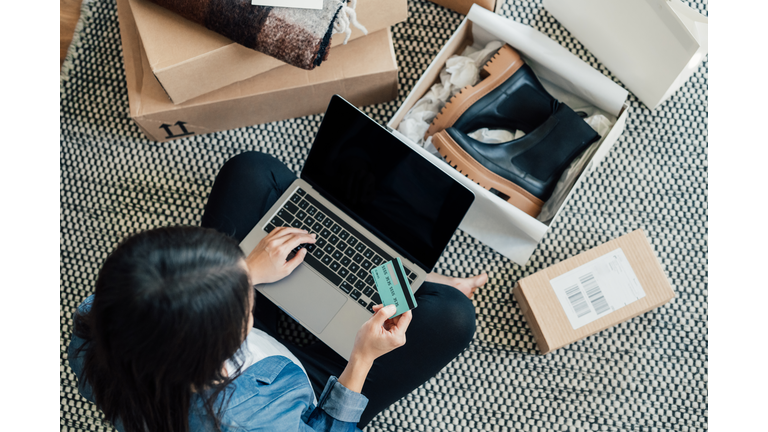 Young Woman Shopping Online While Relaxing At Home