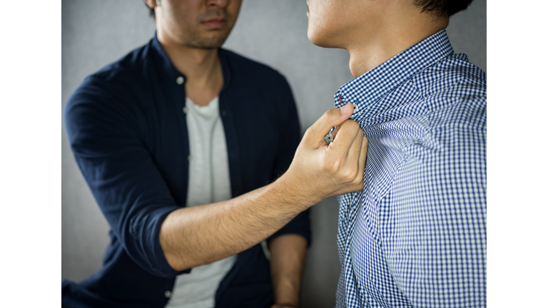 Man grab other by the collar, having argument
