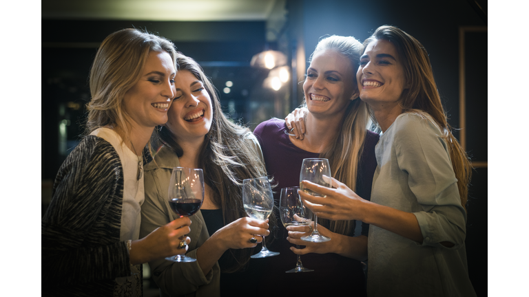 Cheerful female friends enjoying drinks in bar