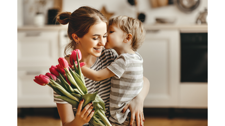 happy mother's day! child son gives flowers for  mother on holiday