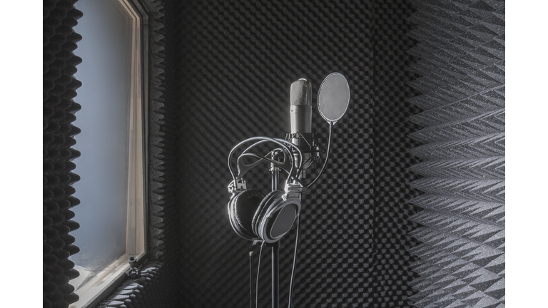 Close-up of headphones on microphone stand in soundproof recording studio