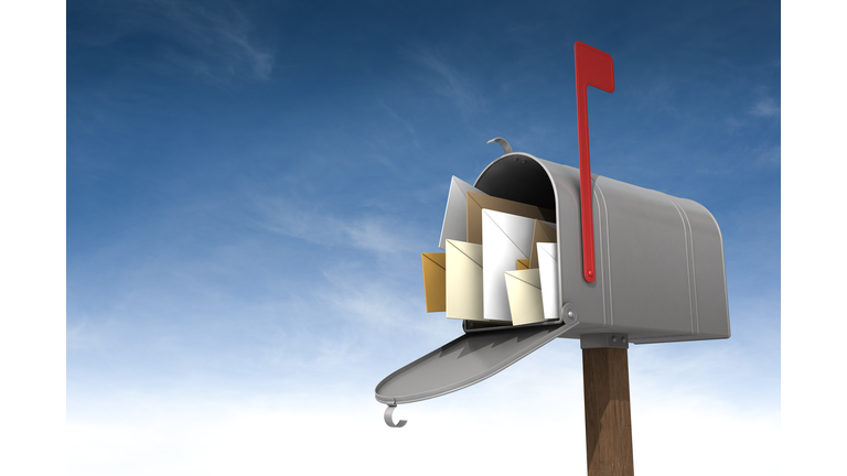 A metal mailbox filled with letters against the sky
