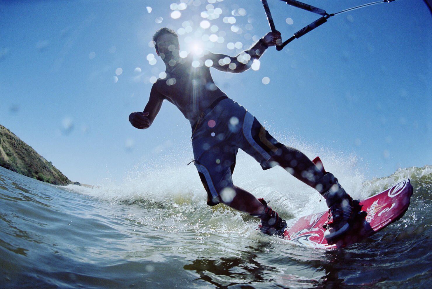 Young man wakeboarding on lake, low angle view