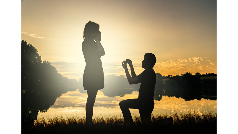 Wedding proposal. Dating at sun set. Man giving ring.