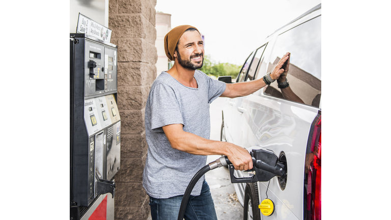 Hispanic man pumping gas