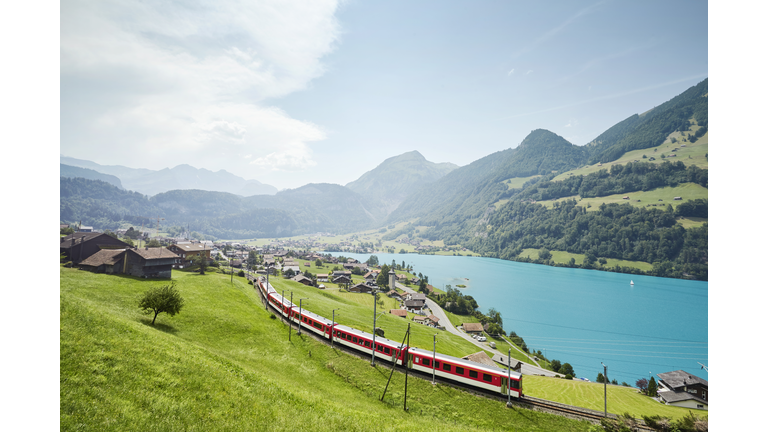 Lush Swiss landscape with commuter train and lake, Lungern, Obwalden, Switzerland
