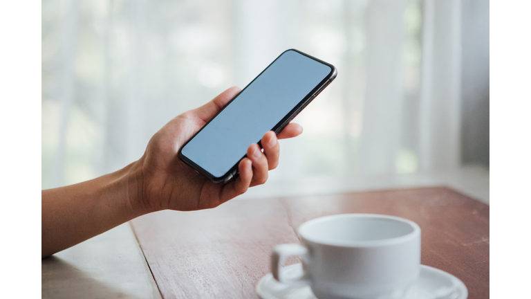 Close-up Shot Of Female Hand Holding A Smart Phone With Blank Screen