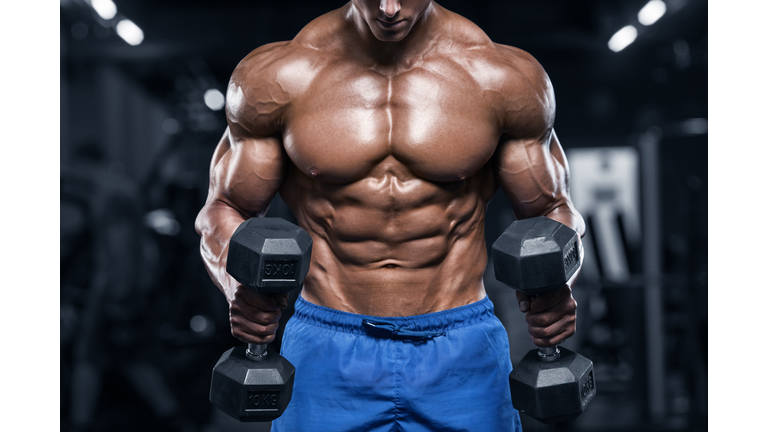 Muscular man working out in gym, strong male torso abs