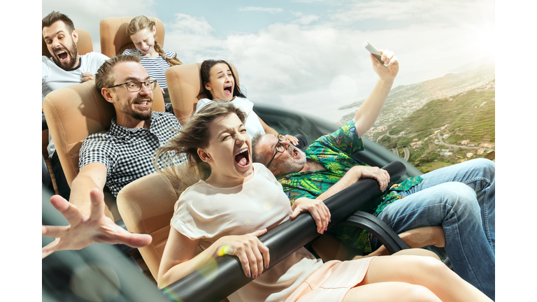 The happy emotions of men and women having good time on a roller coaster in the park