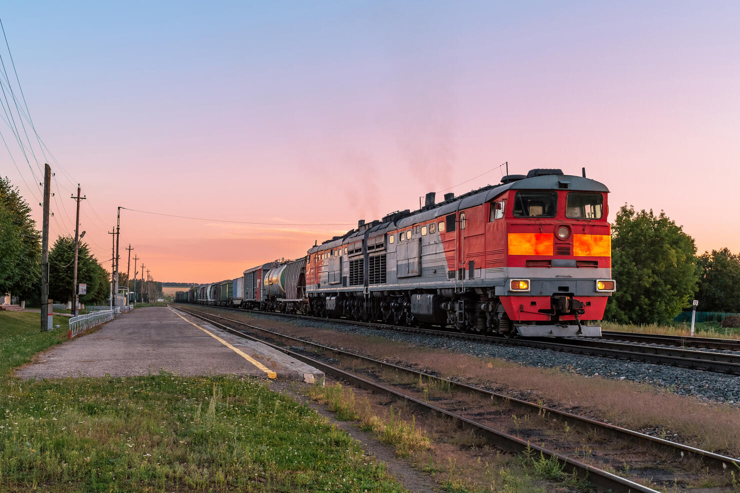 Powerful diesel locomotive with a heavy freight train in a beautiful sunset light