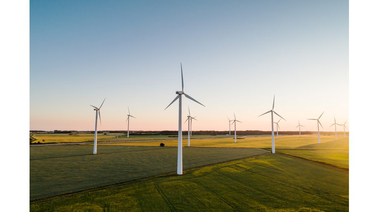 Wind turbines on agricultural land against clear sky