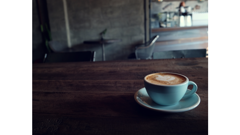 cup of coffee on table in cafe - vintage style effect picture