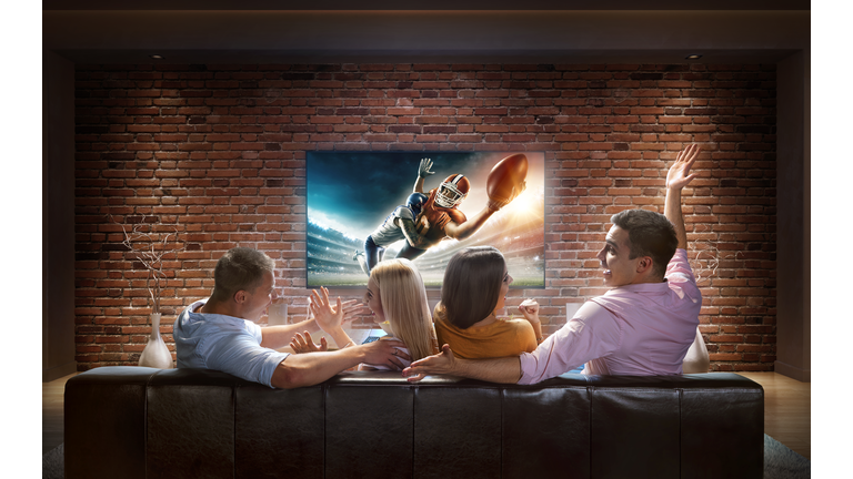 Couples watching American football game at home