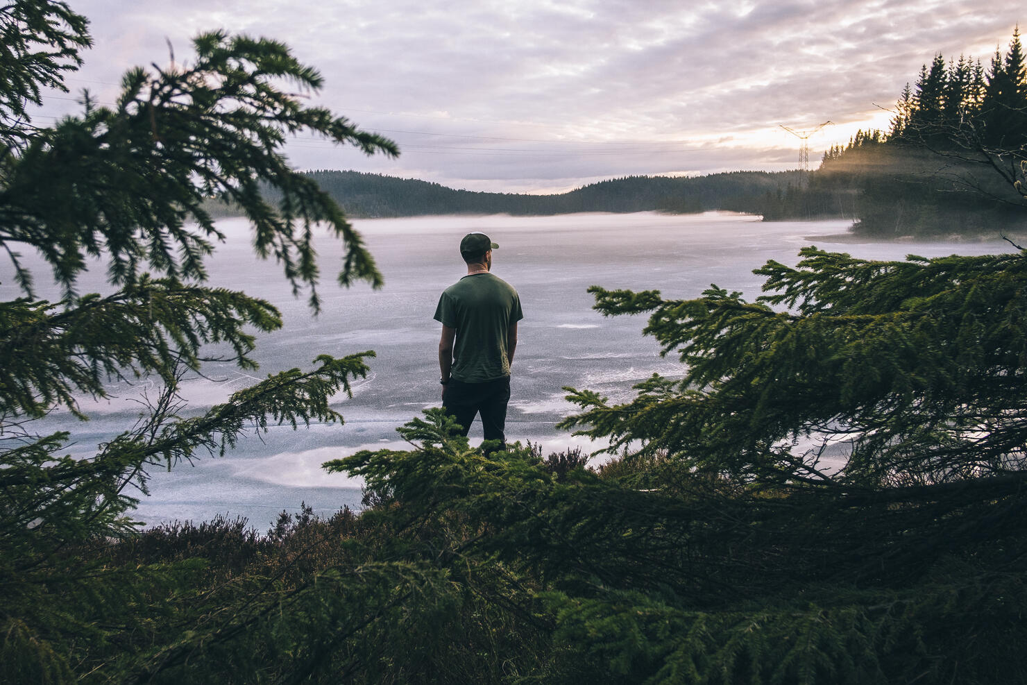 Hiker looking at the view over a lake in sunset.