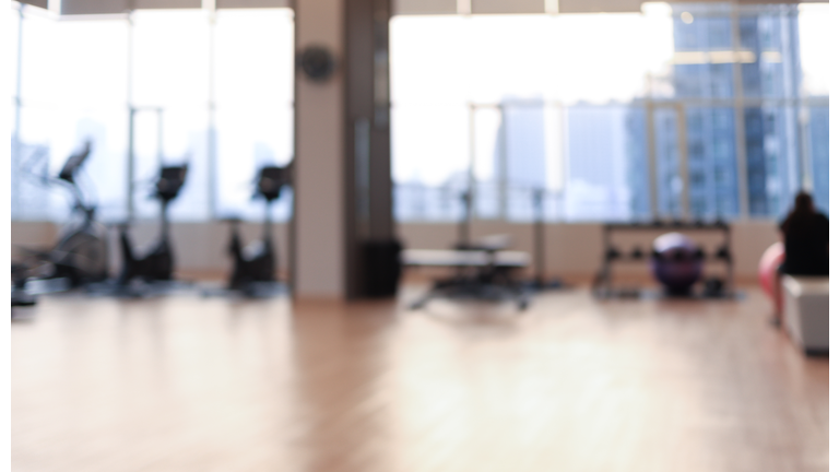 Blurred fitness room with Modern light gym. Sports equipment in gym.