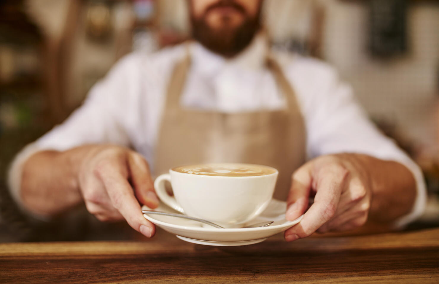 Barista serving cup of fresh coffee for you