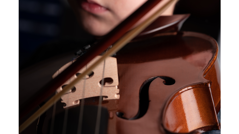 Blurred Violinist closeup. Detail of violin on black background