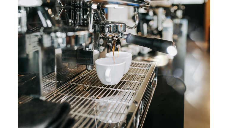 Human hands making fresh espresso coffee drink